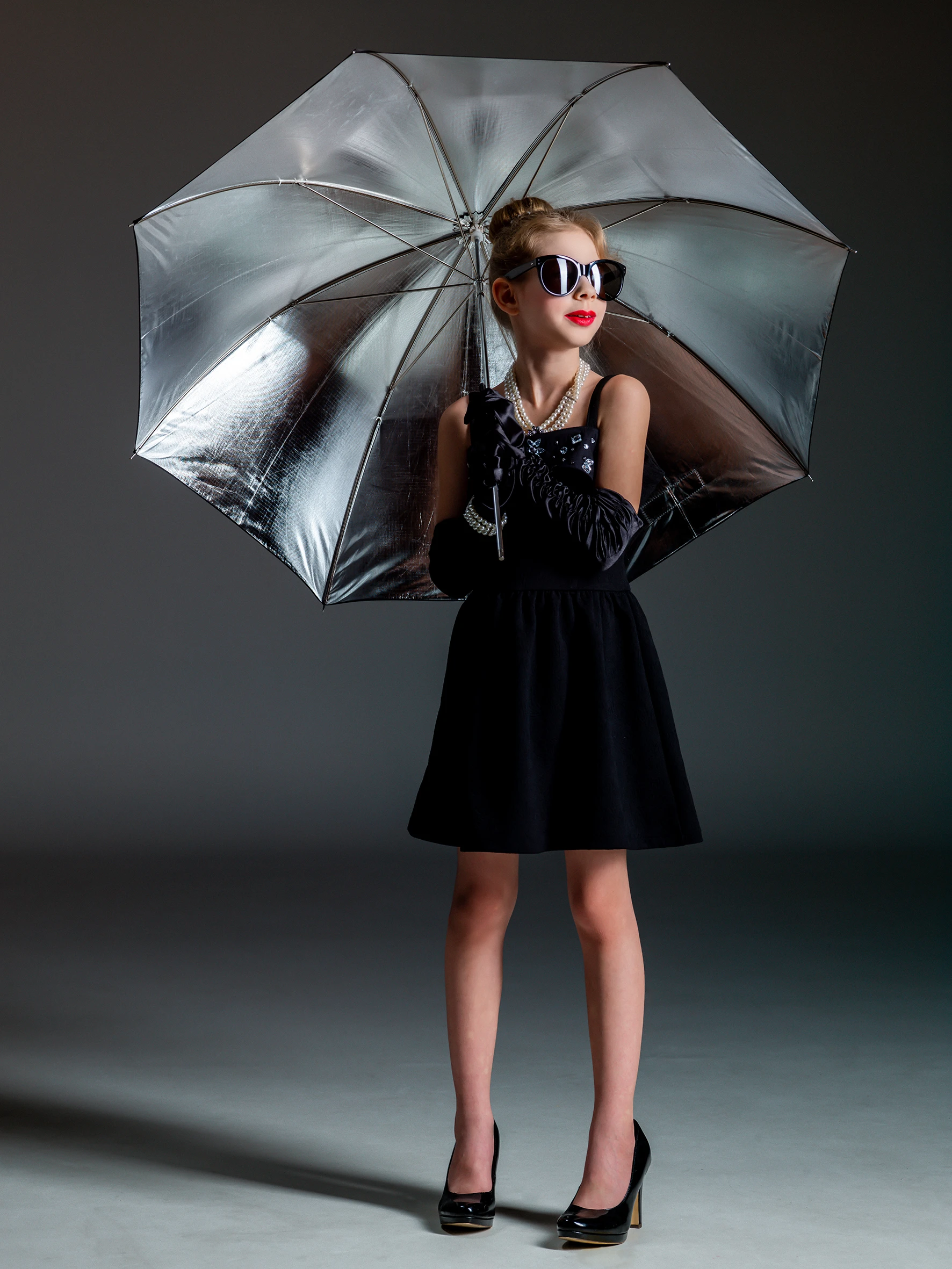 young girl holding an umbrella in a 50s like set